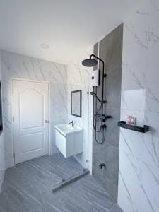 La salle de bains est pourvue d'un lavabo et d'une porte blanche. dans l'établissement AnJia Villa, à Pattaya (sud)