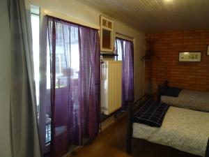 a bedroom with a bed and two windows with curtains at B&B Piccardie in Emlichheim