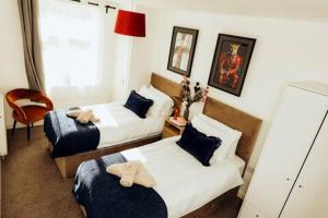 a hotel room with two beds and a chair at Bromley Stylish Modern Escape 2 Bed Apartment in Bickley