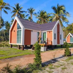 a house on the beach with palm trees in the background at Koh kood Neverland beach resort in Ko Kood