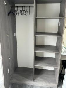 a closet with wooden shelves in a room at Premier City Centre Room- Ensuite in Nottingham +8 photos