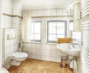 a white bathroom with a toilet and a sink at Centralapartment J3 in Schwerin