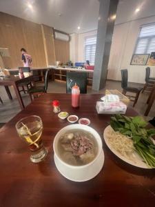 una mesa con un tazón de sopa y una copa de vino en Happy Hotel Here, en Nha Trang