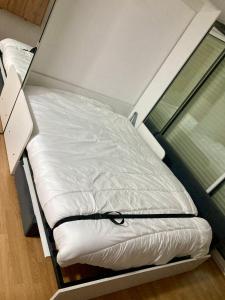 un letto bianco in una stanza con una finestra di Studio à Guzet Neige aux pieds des Pistes et de Ecole de Ski a Ustou