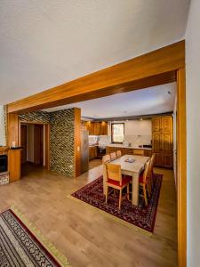 una sala da pranzo e una cucina con tavolo e sedie di Bjelasnica Alpine Retreat - Cozy Mountain House near Sarajevo a Trnovo