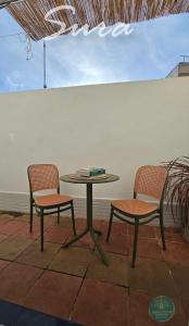 two chairs and a table and a table and two chairs at SURA by Sanlucar Housing in Sanlúcar de Barrameda +29 photos