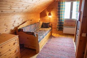 ein Schlafzimmer mit einem Bett in einer Holzhütte in der Unterkunft Mäkelän Lomatuvat Cottages in Korkeakoski