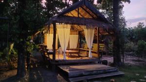 a gazebo in a forest with a dog sitting in it at พายิ้มฟาร์มสเตย์ in Ban Nam Khrai