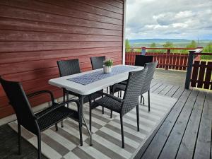 a table and chairs on a wooden deck at The view of Skattungbyn in Skattungbyn +18 photos