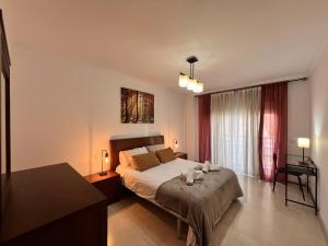 a bedroom with a bed and a table and a window at Chicflat Avenida España Ideal para familias in Estepona +30 photos