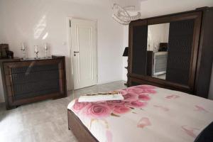 a bedroom with a bed with pink roses on it at Ostoja Bachus in Sawin