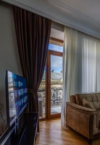 Una sala de estar con un sofá y una puerta corrediza de vidrio. en Sahil Luxury Apartment, en Baku