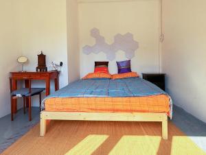 Un dormitorio con una cama, una mesa y un escritorio. en Regalohome Bkk, en Bangkok