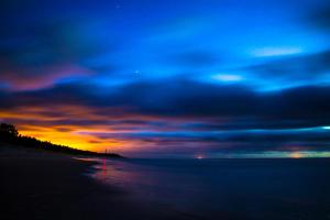 a sunset on the beach with a cloudy sky at Šalia bokšto in Šventoji