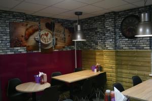 a restaurant with two tables and a clock on the wall at Chris's Motel in Stokenchurch