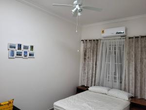 una camera da letto con un letto e un ventilatore a soffitto di Serene Oasis in East Legon Hills - Chic 2 Bedroom Retreat a Maijaw