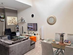 un soggiorno con un divano e un tavolo di vetro di Serene Oasis in East Legon Hills - Chic 2 Bedroom Retreat a Maijaw