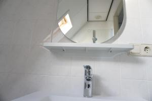 a white bathroom with a sink and a mirror at Kustverhuur, Park Schoneveld, Stern 233 in Breskens