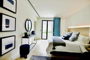 ein Schlafzimmer mit einem großen Bett und einem Spiegel in der Unterkunft Villa Qalaisie - Luxury Villa for 16 on Terre Blanche Golf Estate in Tourrettes