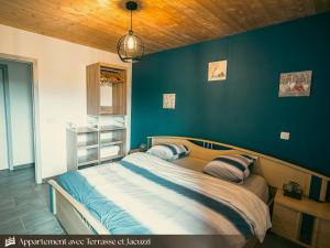 Terrasse 2-1 Appartements du Pont Alsort في فرويد-شابيل: غرفة نوم بها سرير وجدار أزرق +10 صور