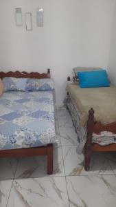 deux lits côte à côte dans une pièce dans l'établissement Casa de praia itanhaem, à Itanhaém