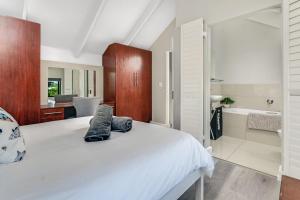 a bedroom with a bed and a bathroom with a tub at Tranquil Lagoon Loft in Knysna