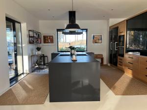 a kitchen with a black island in the middle at Unique lakehouse Villa Valo in Hollola