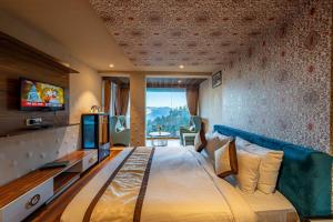 a hotel room with a large bed and a television at Aamari Resort in Rāmgarh