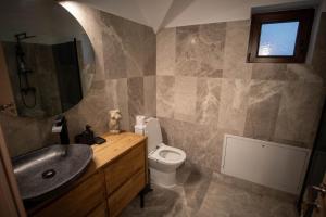 a bathroom with a sink and a toilet and a mirror at The Rock - Moieciu in Cheia