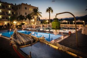 a boat sitting next to a pool at a resort at Club Hotel Kennedy in Roccella Ionica