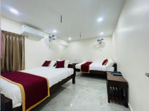 una camera d'albergo con due letti e un tavolo di KS Rever Residency a Pondicherry