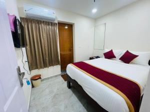 una camera d'albergo con un letto e una televisione di KS Rever Residency a Pondicherry