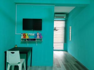 a blue room with a table and a television at WORLD KIDS FANTASY in Lumut