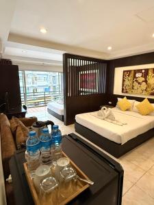 a hotel room with two beds and a table with water bottles at Thai Classic House in Patong Beach