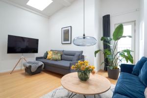 a living room with a blue couch and a table at Penthouse-Nordic-Citycenter-Balcony in Copenhagen