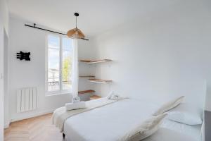 a white bedroom with a bed and a window at L'Azul - Entre Paris & Disney - Wifi in Villemomble