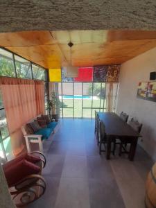een woonkamer met een tafel en een bank bij Casa El Almendro-Barrio Privado - Para 2 personas in Ciudad Lujan de Cuyo