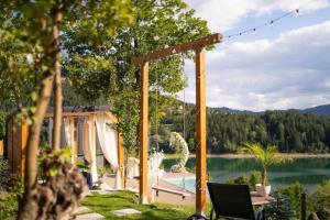 a backyard with a pool and a pergola and a lake at Moon Lake Bicaz - Casa Oia in Buhalniţa
