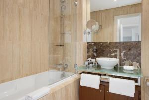 a bathroom with a tub and a sink and a shower at Monte Santo Resort in Carvoeiro