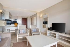 a living room with a couch and chairs and a tv at Monte Santo Resort in Carvoeiro