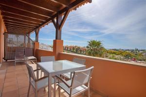 a patio with a white table and chairs on a balcony at Monte Santo Resort in Carvoeiro