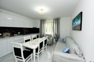 a kitchen and living room with a table and a couch at Villa Buganville in Orikum