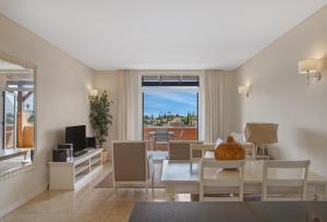 a living room with a table and chairs and a window at Monte Santo Resort in Carvoeiro
