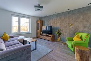 a living room with two couches and a tv at Apartament Novi in Mrągowo
