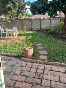 a patio with a table and chairs in a yard at The Garden Cottage in Polokwane
