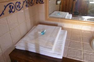 a bathroom with a sink and a mirror and towels at Casa Rural El Zahorí De Pinedas in Pinedas