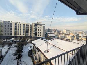 a balcony with snow on the roofs of buildings at Apartman Isak in Banja Luka
