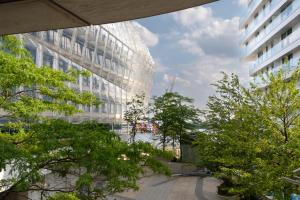 Blick auf ein Gebäude mit Bäumen davor in der Unterkunft Come2Stay Hafencity - Marco Polo Tower 2 in Hamburg