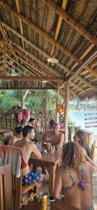 a group of people sitting at a table in a restaurant at White Lion Paradise Dikwella in Batigama