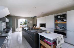 una grande cucina con armadi bianchi e un piano di lavoro nero di Rare Villa luxueuse 250 M2 proche plage Perols a Pérols